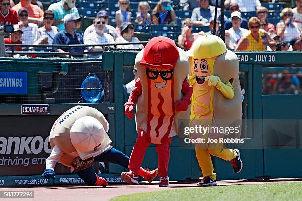 Ketchup trips up Onion as mascots race between innings of the game between the Cleveland Indians and Washington Nationals at Progressive Field on...