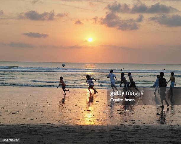 children playing soccer on kuta beach - breaking wave stock pictures, royalty-free photos & images