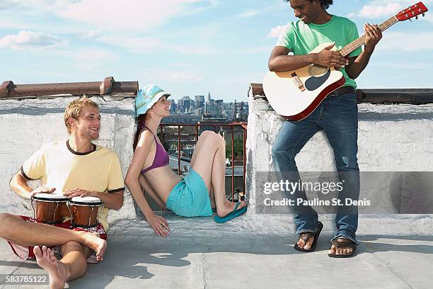 friends enjoying music on rooftop - ボンゴ ストックフォトと画像