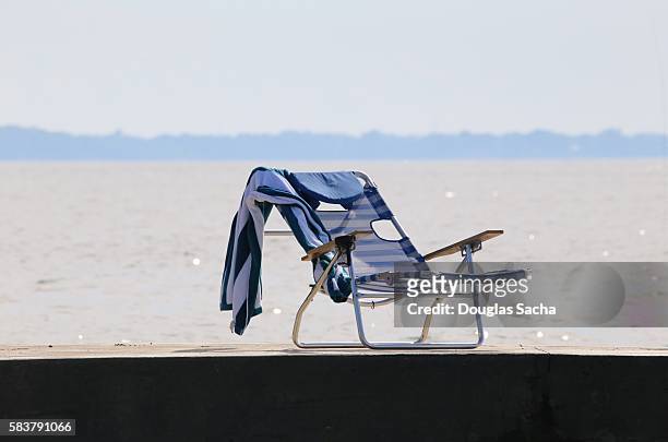 foldable lounge chair and beach towel on a pier - adirondack chair white background stock pictures, royalty-free photos & images