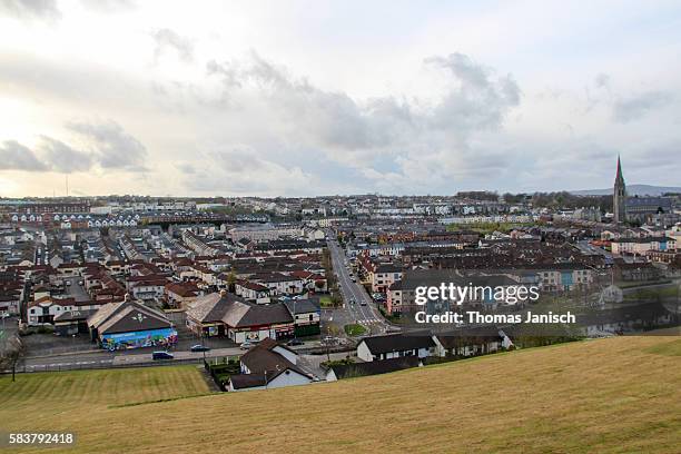 sunset and view over the catholic bogside from the city walls, derry / londonderry, northern ireland, uk - derry northern ireland stock pictures, royalty-free photos & images