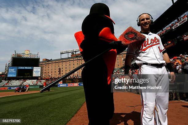 Nolan Reimold of the Baltimore Orioles celebrates with the Oriole Bird mascot after hitting a two run walk-off home run in the ninth inning to defeat...