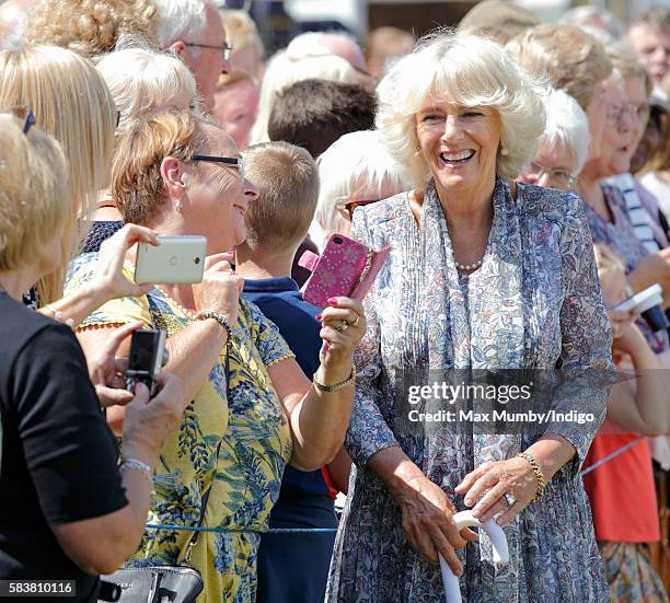 Camilla, Duchess of Cornwall poses for a selfie with a member of the public as she visits the Sandringham Flower Show at Sandringham House on July...