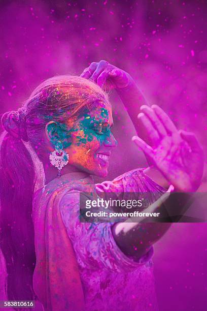 mujer joven celebrando el festival holi - festival holi fotografías e imágenes de stock