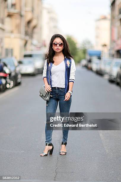 May Berthelot , is wearing a Zara blue bombers jacket featuring a flower and a bird, Topshop blue jeans, H&M sandals, a Cartier Pasha watch, Sarah...