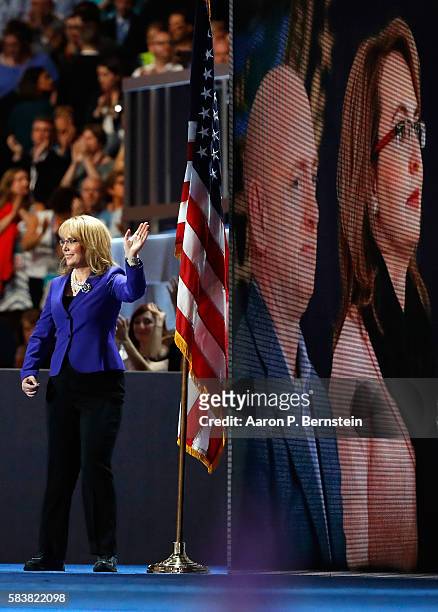 Former Congresswoman Gabby Giffords waves to the crowd as she arrives on stage to deliver remarks on the third day of the Democratic National...