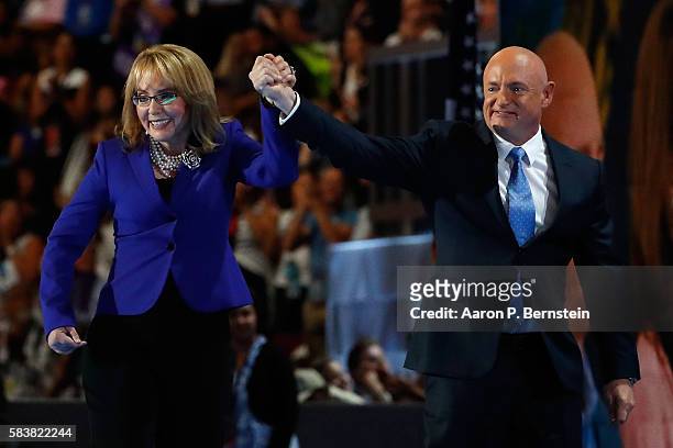 Former Congresswoman Gabby Giffords walks on stage with her husband, retired NASA Astronaut and Navy Captain Mark Kelly, after delivering remarks on...