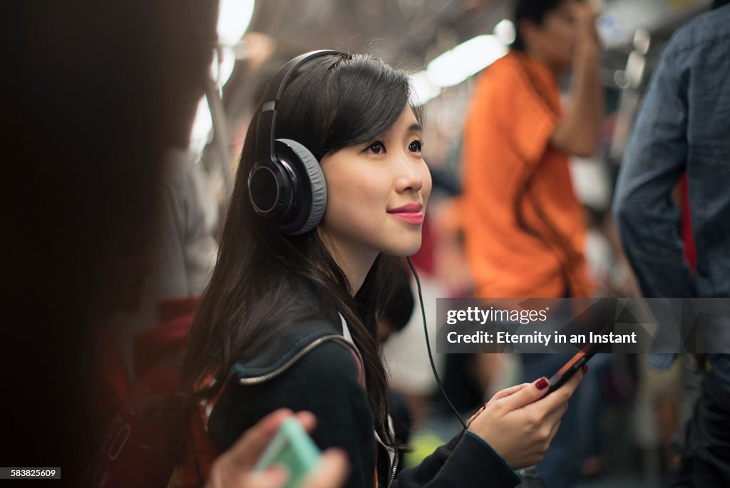 Young woman listening to music while travelling