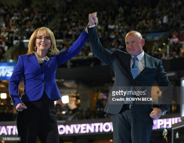 Former Arizona representative Gabby Giffords and astronaut Mark Kelly join hands after addressing delegates on Day 3 of the Democratic National...