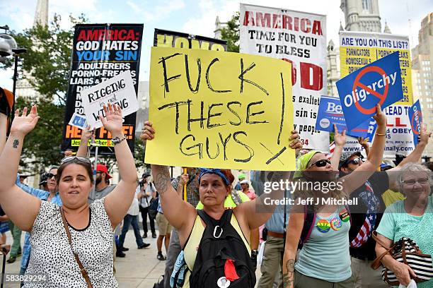 Bernie Sanders supporters hold banners in front of a religious group as they gathered near City Hall on day three of the Democratic National...