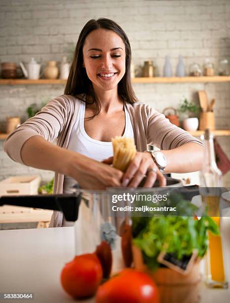 woman cooking spaghetti - macaroni stock pictures, royalty-free photos & images