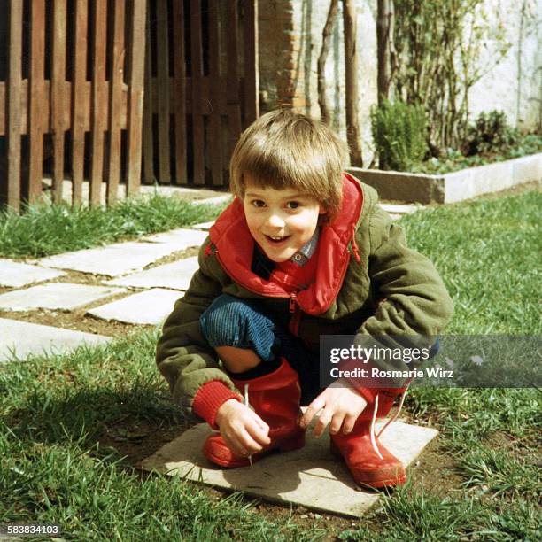 boy in red rubber boots - ambivere stock pictures, royalty-free photos & images
