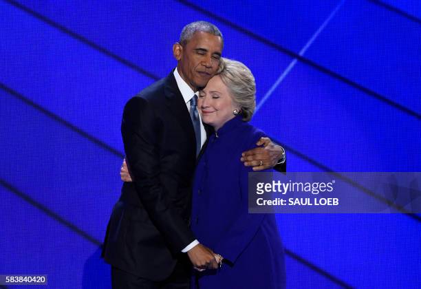 President Barack Obama and Democratic presidential nominee Hillary Clinton embrace on stage during Day 3 of the Democratic National Convention at the...