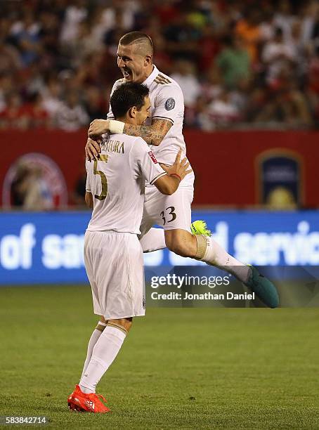 Kucka Juraj of A.C. Milan leaps on teammate Bonaventura Giacomo in celebration after defeating FC Bayern Munich in a friendly match in the...