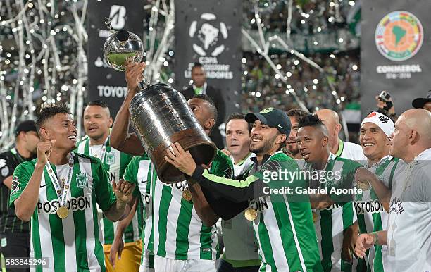 Sebastian Perez of Atletico Nacional lifts the trophy after a second leg final match between Atletico Nacional and Independiente del Valle as part of...