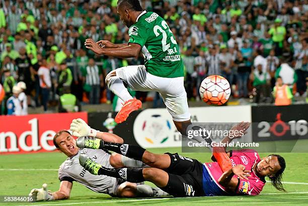 Miguel Borja of Atletico Nacional vies for the bal with Libardo Azcona goalkeeper and Arturo Mina of Independiente del Valle during a second leg...