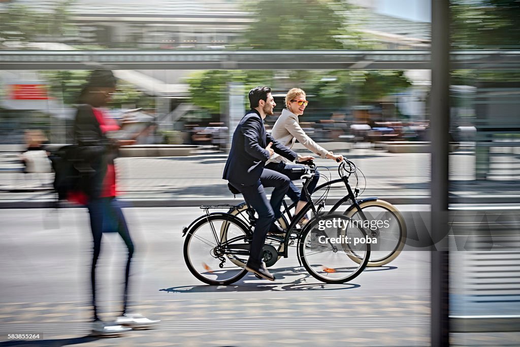 Two business people riding bicycle