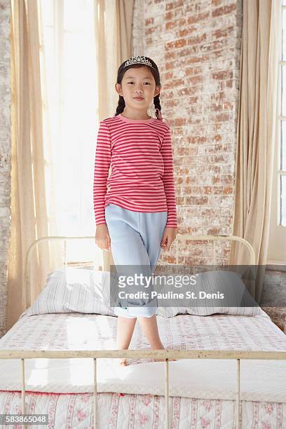 girl standing on bed - girl bedroom stock pictures, royalty-free photos & images