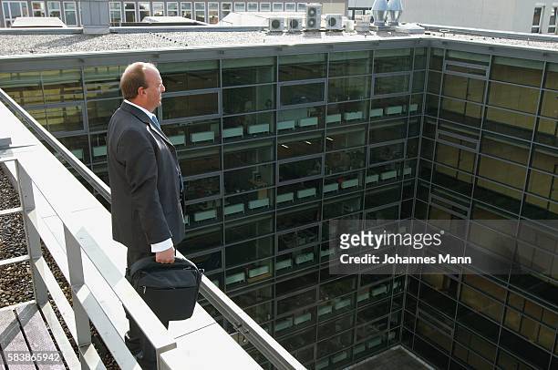 businessman standing on ledge - suicide stock pictures, royalty-free photos & images