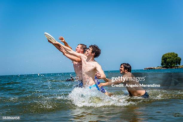 Four young friends jump for a frisbee in Lake Erie on July 28, 2015 in Cleveland, Ohio. Many Cleveland residents spent the day at Edgewater Park to...