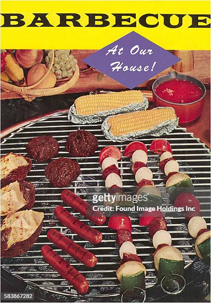 Vintage color photograph of the top of a barbecue grill cooking kebabs, hot dogs, hamburgers, corn and baked potatoes, 1950’s. Large letters in black...