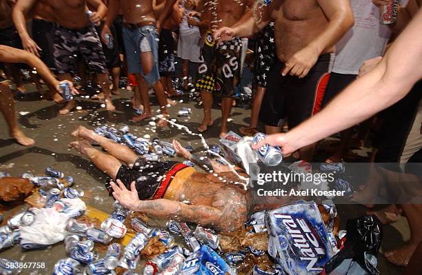 Participants in the annual Fourth fo July Hermosa Beach Ironman festival party after a short run and paddle on their surf boards. The actual...