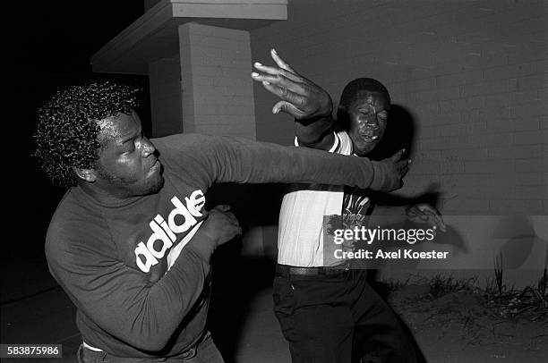 Members of the Grape Street Crips enjoy a friendly fight after partying late in the evening. The Grape Street Watts Crips are a mostly African...