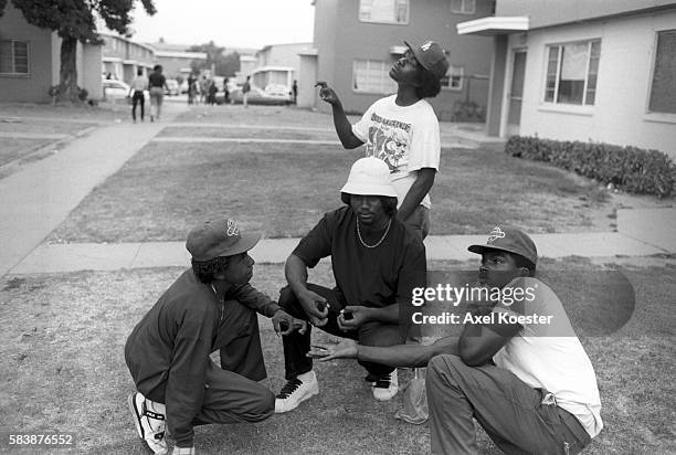 Members of the Grape Street Crips pose "throwing" their signature 'G' and 'W' hand signs. The Grape Street Watts Crips are a mostly African American...