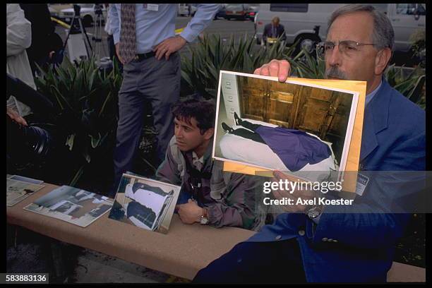 Officials of the San Diego Sherriff's department hold photographs of some of the 39 members of the Heaven's Gate religious group, who committed...