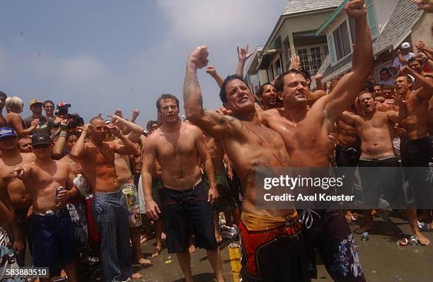 Participants in the annual Fourth fo July Hermosa Beach Ironman festival party after a short run and paddle on their surf boards. The actual...