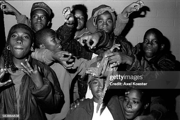 Members of the Grape Street Crips pose "throwing" their signature 'G' and 'W' hand signs. The Grape Street Watts Crips are a mostly African American...
