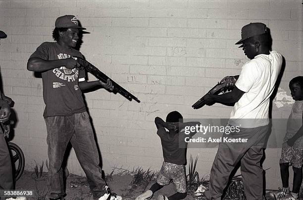 Members of the Grape Street Crips stage a mock execution by taking a neighborhood pre-schooler who happened to wear a red T-shirt and pointing their...