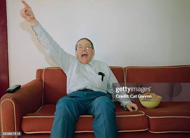 man cheering while sitting on couch - excited funny stock-fotos und bilder