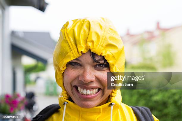 portrait of young woman in raincoat - african american women wet stock-fotos und bilder