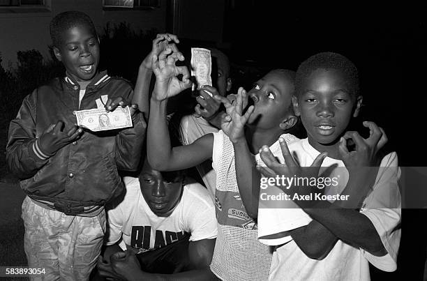 Members of the Grape Street Crips pose "throwing" their signature 'G' and 'W' hand signs. The Grape Street Watts Crips are a mostly African American...