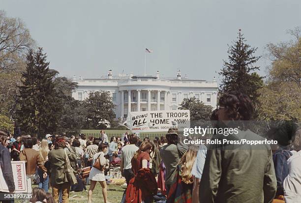 View of anti Vietnam War demonstrators standing and protesting outside the White House during a march to the Pentagon in Washington DC to plead for...