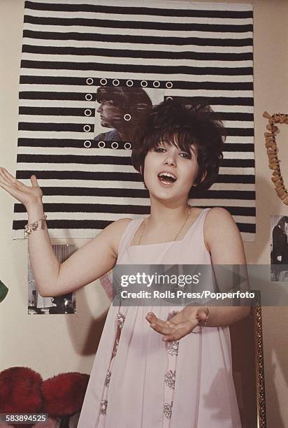 English actress and singer, Adrienne Posta pictured singing in an apartment circa 1965.
