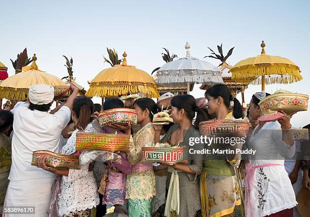 people wearing traditional dress during melasti festival - nyepi stock pictures, royalty-free photos & images