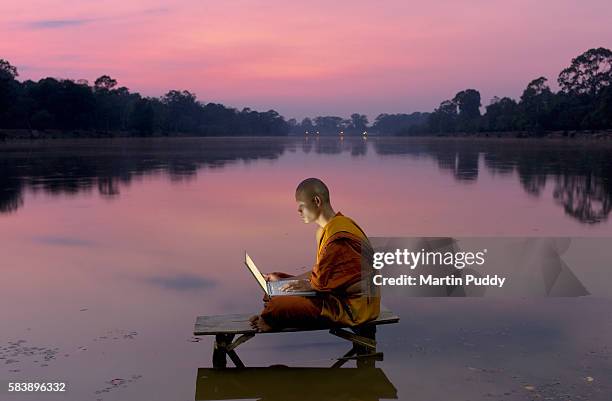 buddhist monk using laptop computer - buddhism imagens e fotografias de stock