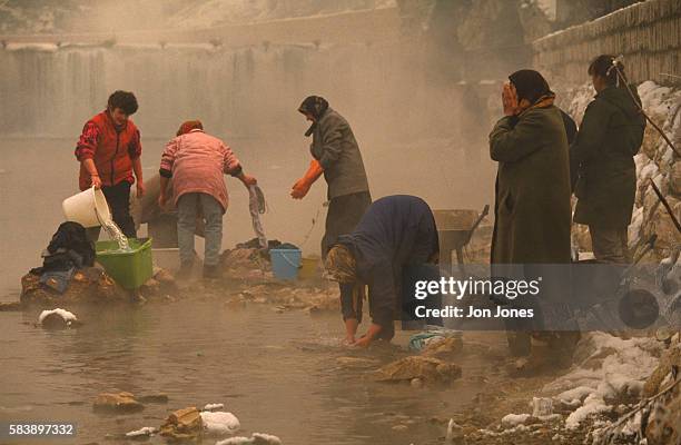 Women wash clothes in the river during the first winter of the siege.