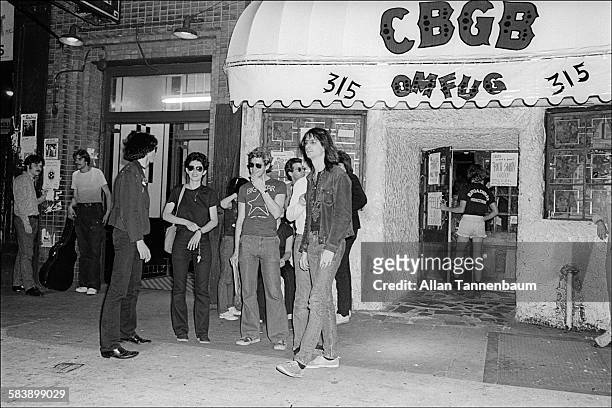 American musician Lenny Kaye, of the Patti Smith Group, takes a break outside CBGB on the Bowery, New York, New York, May 28, 1977.