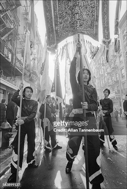 Low-angle view of Chinatown residents as they march and celebrate the Year of the Tiger with a banners and flags, New York, New York, January 15,...