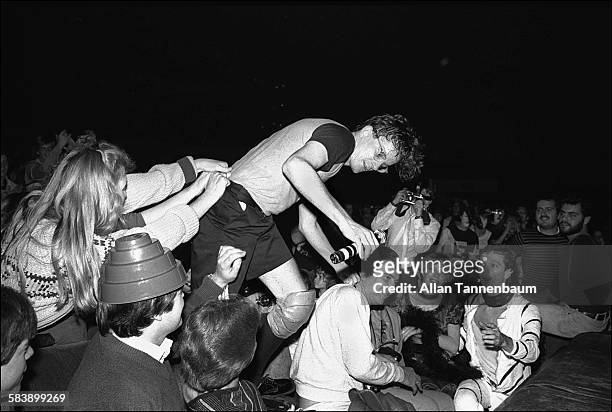 American New Wave musician Mark Mothersbaugh, of the group Devo, climbs among concert goers during a performance at Radio City Music Hall, New York,...