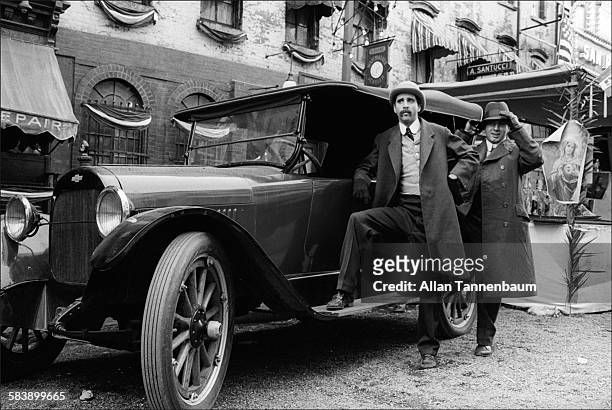 Two extras pose by an antique car on the East Village set of the film 'The Godfather Part II' , New York, New York, March 10, 1974.