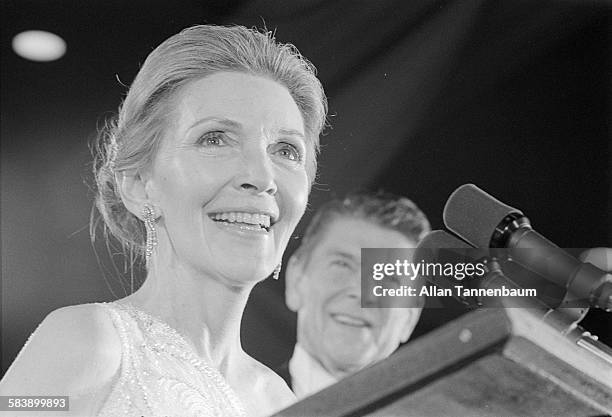 First Lady Nancy Reagan speaks at the inaugural ball, as her husband, newly-elected US President Ronald Reagan, looks on, Washington DC, January 20,...