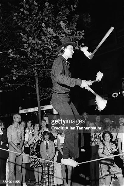 Nighttime view of French wire dancer and acrobat Phillipe Petit as he juggles on a tightrope for a sidewalk audience near Lincoln Center, New York,...