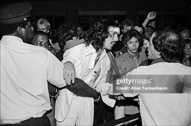 Outside Studio 54, a doorman holds back would-be clubgoers as they appeal to owner Steve Rubell for admission, New York, New York, July 20, 1978.