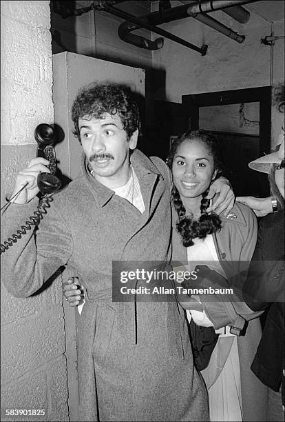 Mexican-born American musician Carlos Santana takes a telephone call backstage at Roseland after a concert, New York, New York, March 4, 1977.