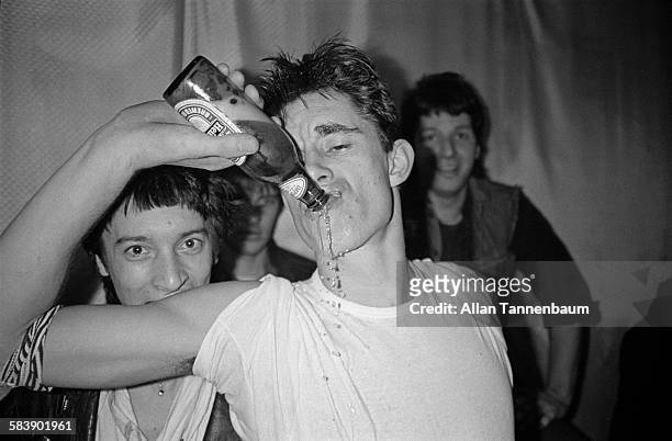 British musician Jimmy Pursey, of the group Sham 69, drinks a Heineken backstage at the Mudd Club after a performance, New York, New York, December...