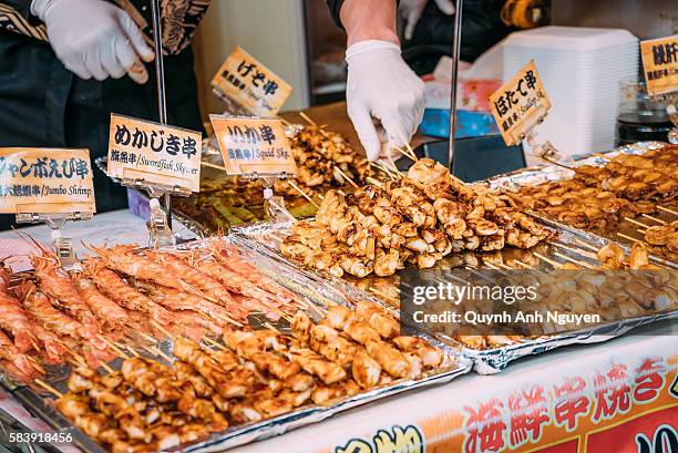 japan -  grilled seafood for sale at tsukiji market in tokyo - mercato del pesce di tsukiji foto e immagini stock